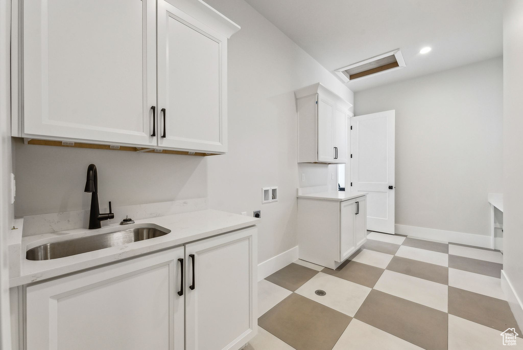 Clothes washing area featuring washer hookup, attic access, electric dryer hookup, a sink, and light floors