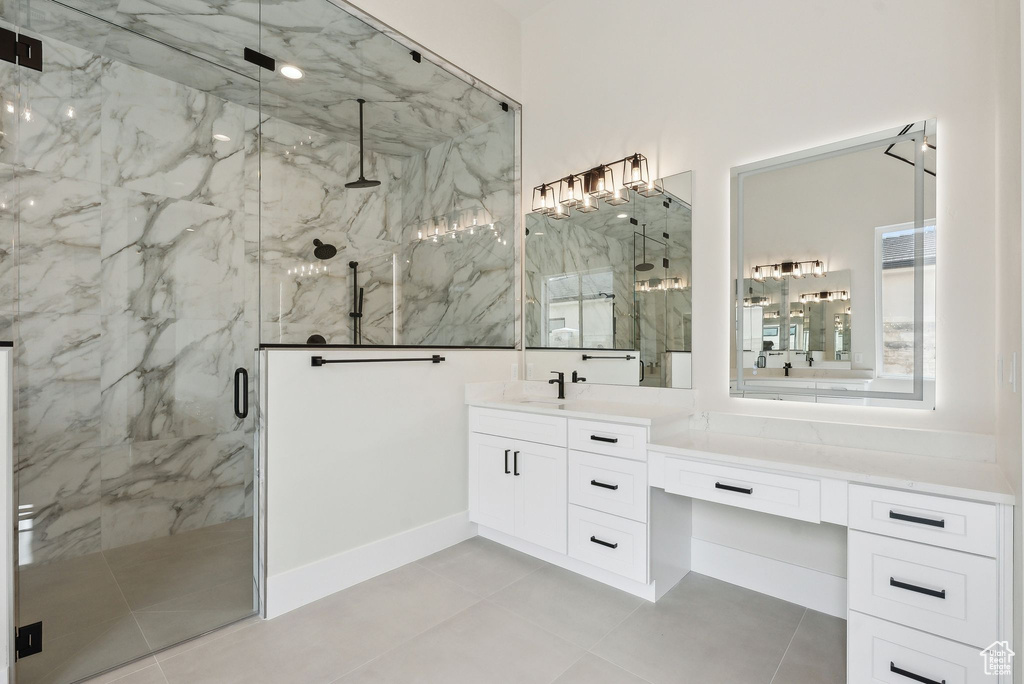 Full bathroom featuring tile patterned floors, a marble finish shower, and vanity