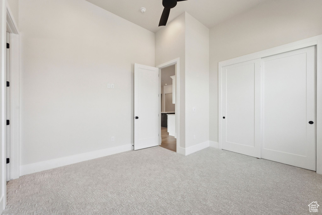 Unfurnished bedroom featuring a closet, carpet flooring, and baseboards