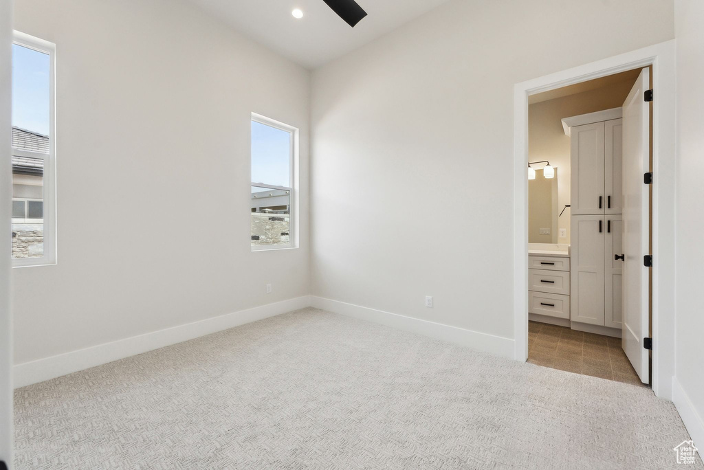 Unfurnished bedroom with baseboards, light carpet, and connected bathroom