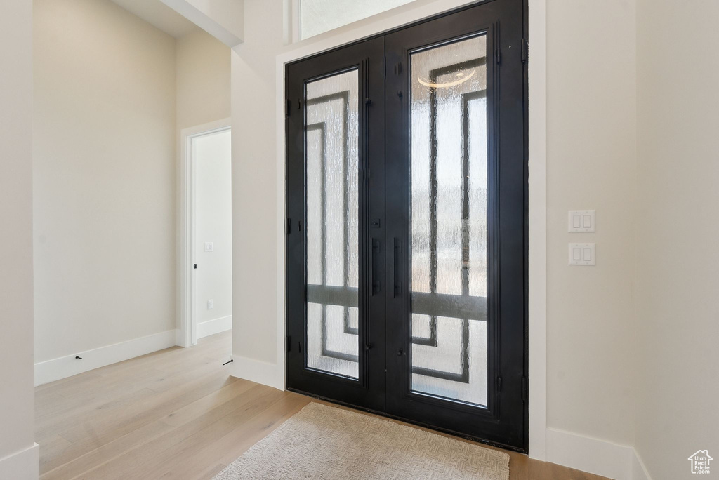 Entryway with french doors, baseboards, and wood finished floors