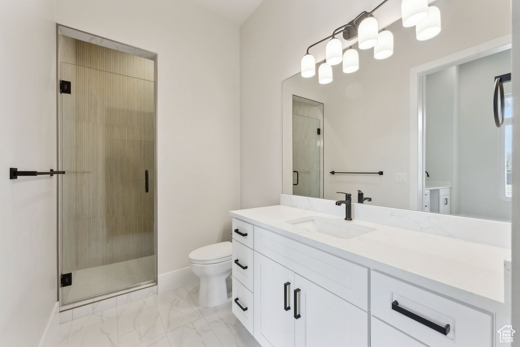 Full bathroom with a stall shower, vanity, baseboards, toilet, and marble finish floor