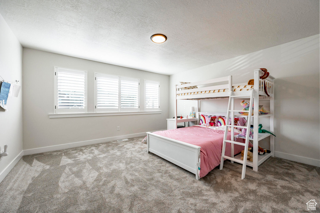 Bedroom with carpet flooring and a textured ceiling