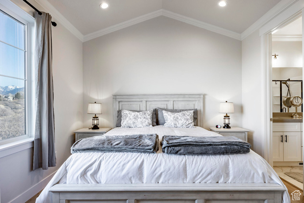 Bedroom featuring crown molding, wood-type flooring, ensuite bathroom, and lofted ceiling