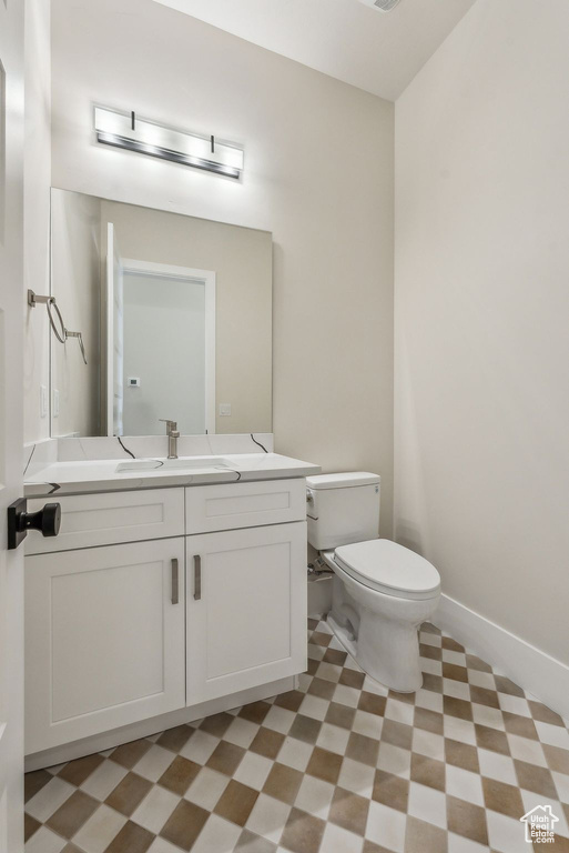 Bathroom featuring tile patterned floors, vanity, and toilet