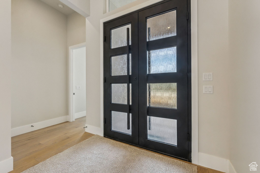 Foyer featuring baseboards, french doors, and wood finished floors
