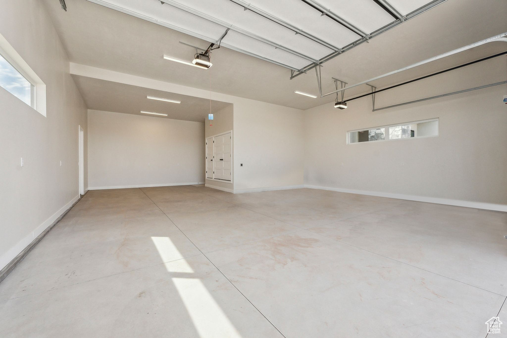 Garage featuring baseboards and a garage door opener