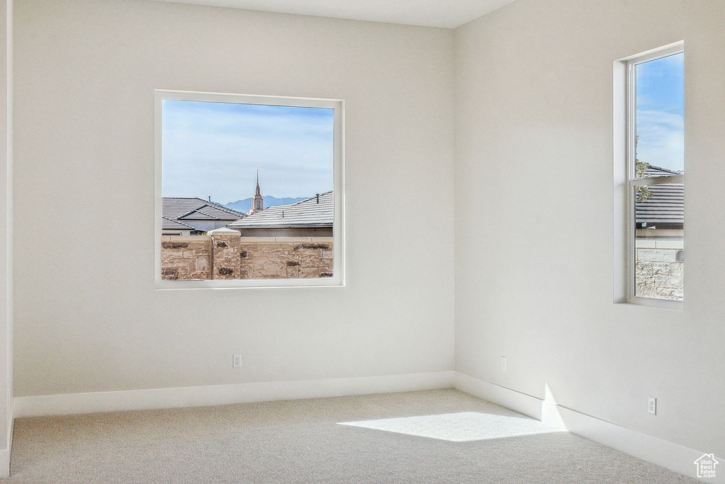 Carpeted empty room featuring baseboards
