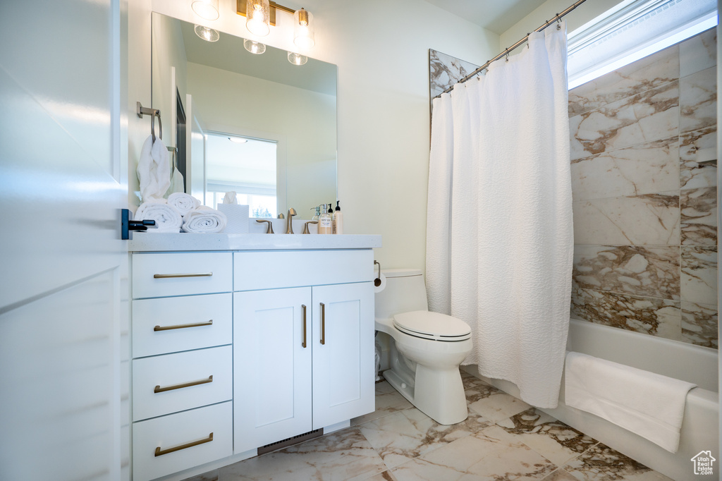 Full bathroom featuring shower / tub combo with curtain, toilet, vanity, and tile flooring