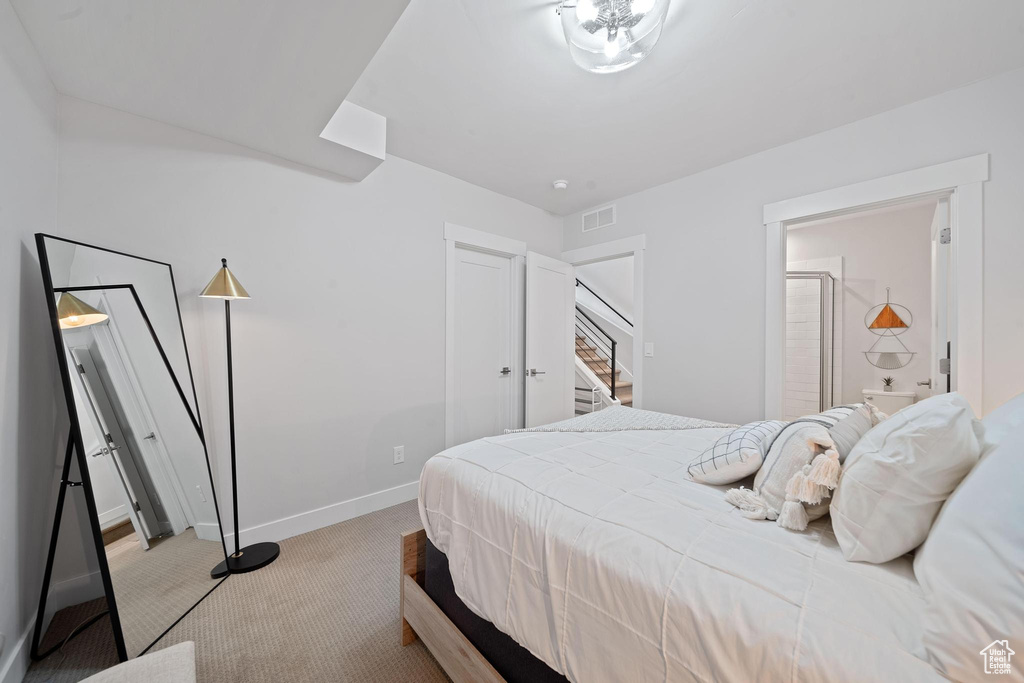 Bedroom with light colored carpet and ensuite bath