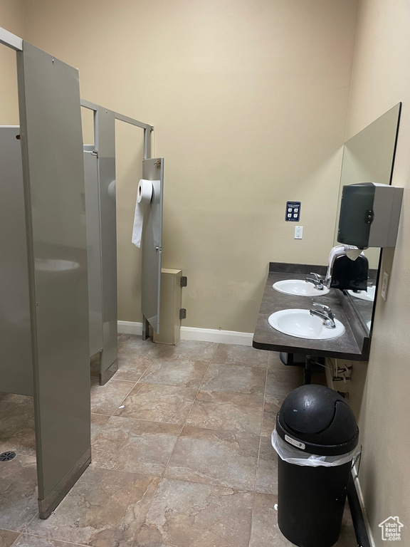 Bathroom with tile floors, double sink, and walk in shower