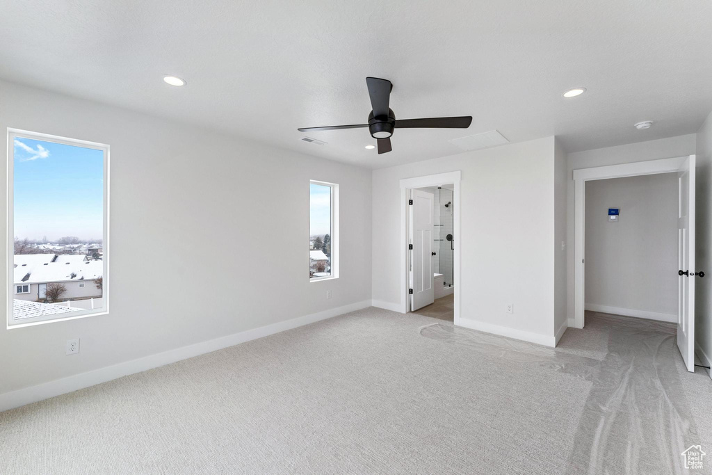 Unfurnished bedroom featuring ensuite bathroom, ceiling fan, and light carpet