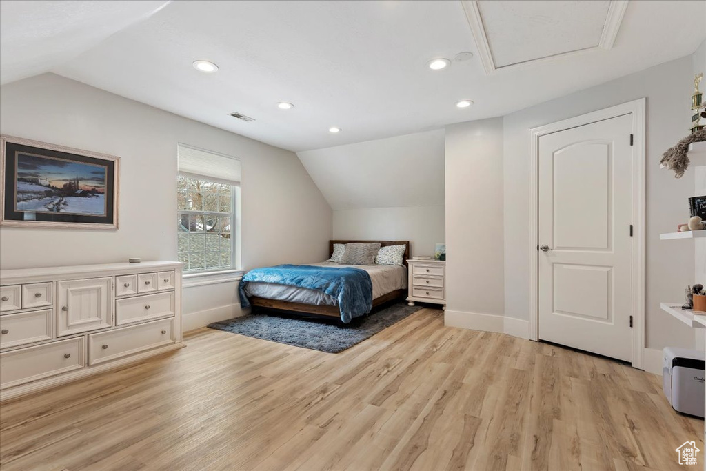Bedroom with vaulted ceiling and light hardwood / wood-style floors