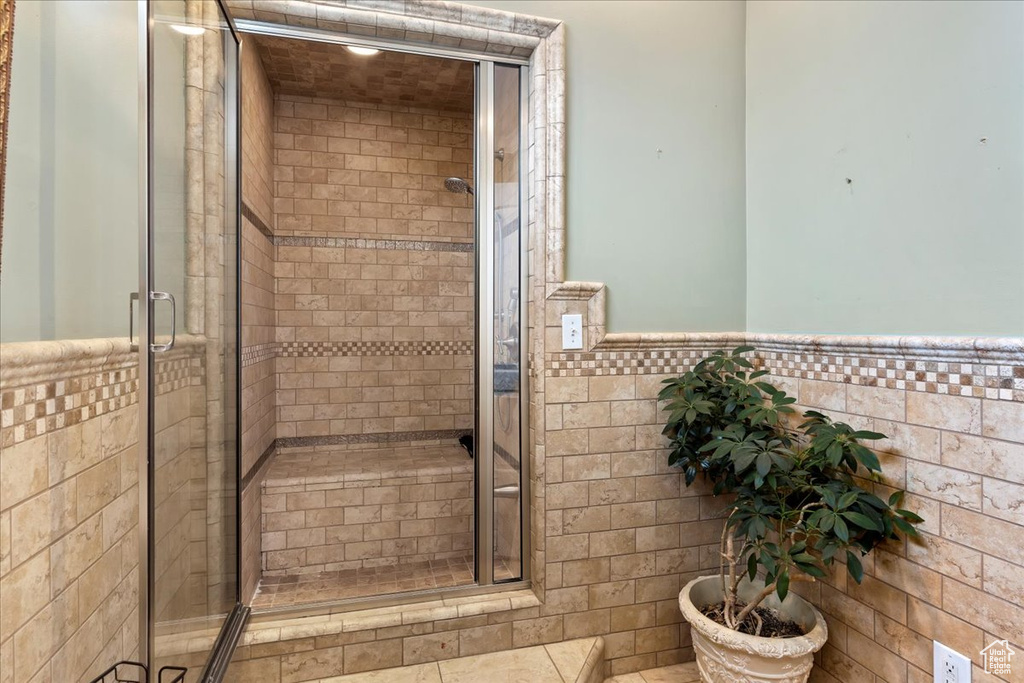 Bathroom with tile walls and a shower with door