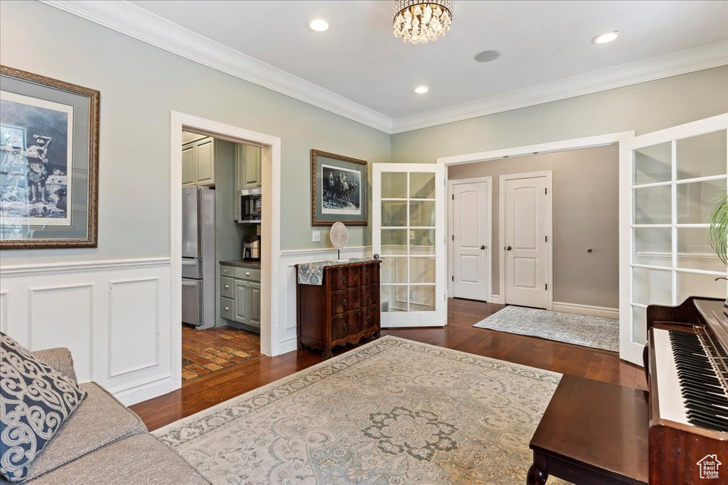 Entrance foyer featuring crown molding, a chandelier, and dark hardwood / wood-style floors