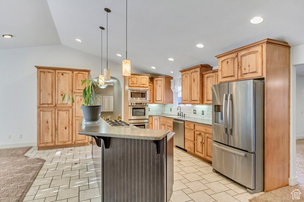 Kitchen featuring stainless steel appliances, tasteful backsplash, light tile floors, and a kitchen bar