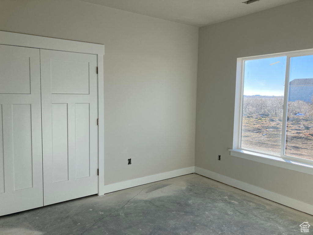 Unfurnished bedroom featuring a closet and concrete floors