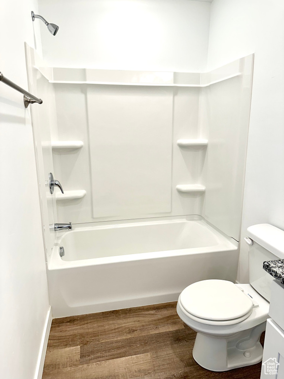 Full bathroom with vanity, toilet, tub / shower combination, and hardwood / wood-style floors