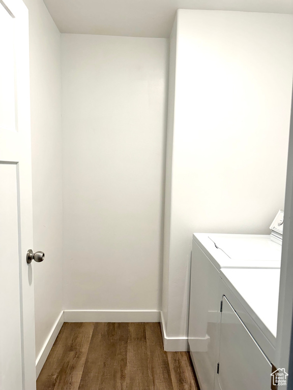 Washroom featuring dark hardwood / wood-style floors and washing machine and dryer