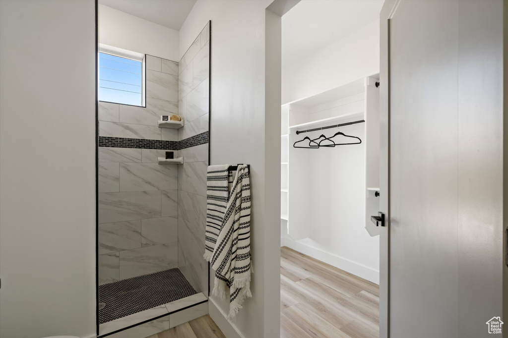 Bathroom with wood-type flooring and tiled shower