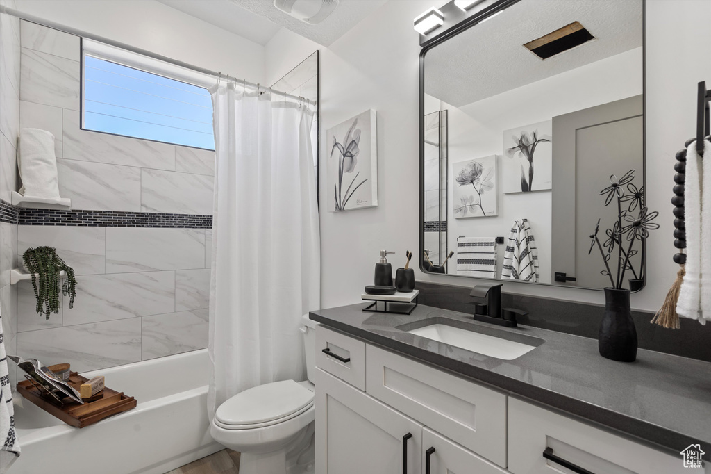 Full bathroom with shower / bath combination with curtain, toilet, and vanity
