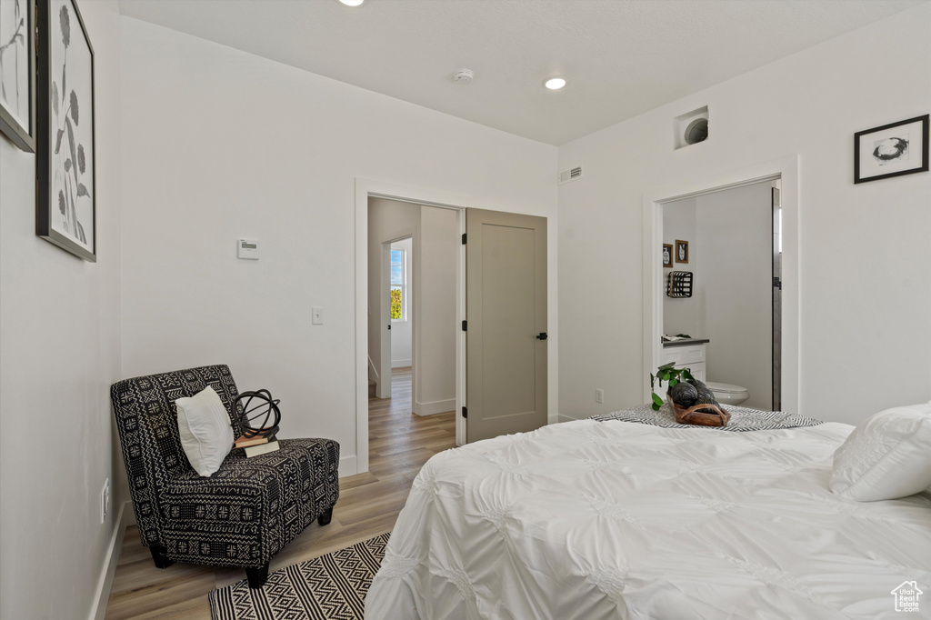 Bedroom featuring ensuite bathroom and light hardwood / wood-style floors
