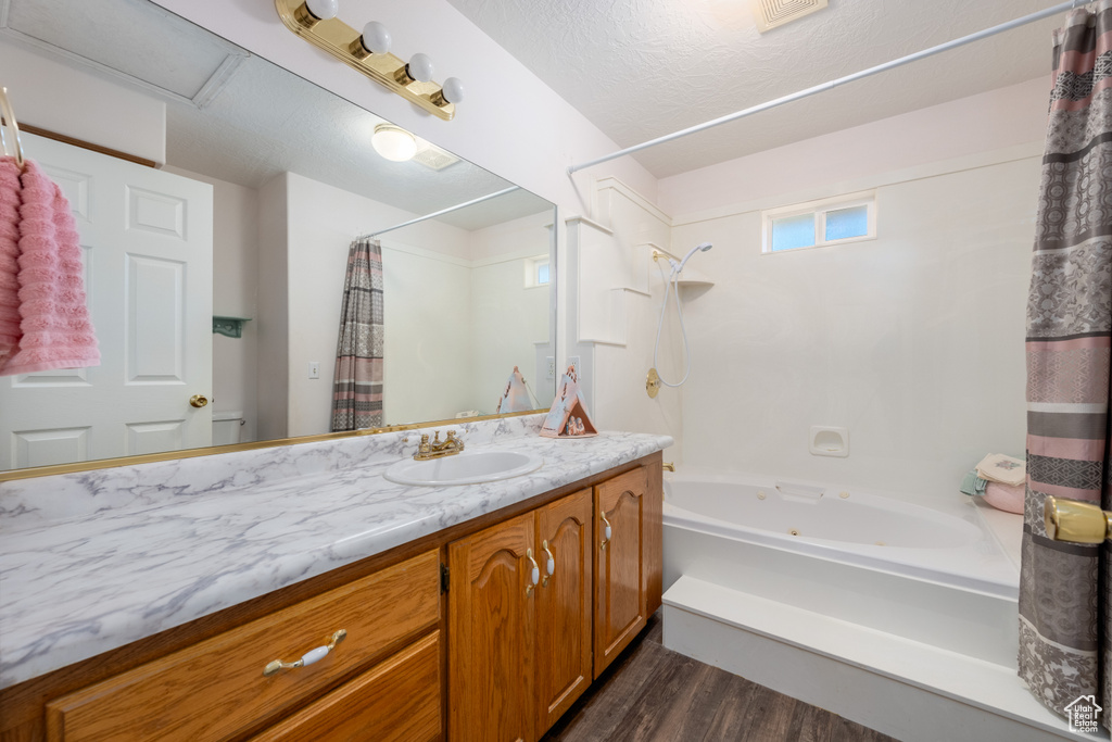 Bathroom with vanity, shower / bath combination with curtain, and hardwood / wood-style floors