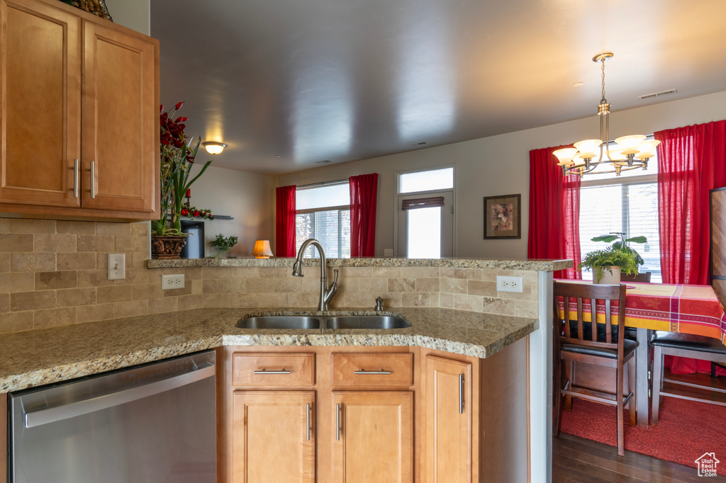 Kitchen featuring an inviting chandelier, a wealth of natural light, sink, and dishwasher