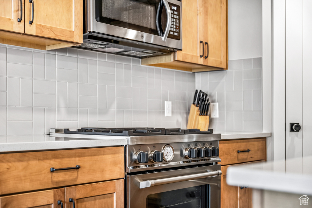 Kitchen with stainless steel appliances and backsplash