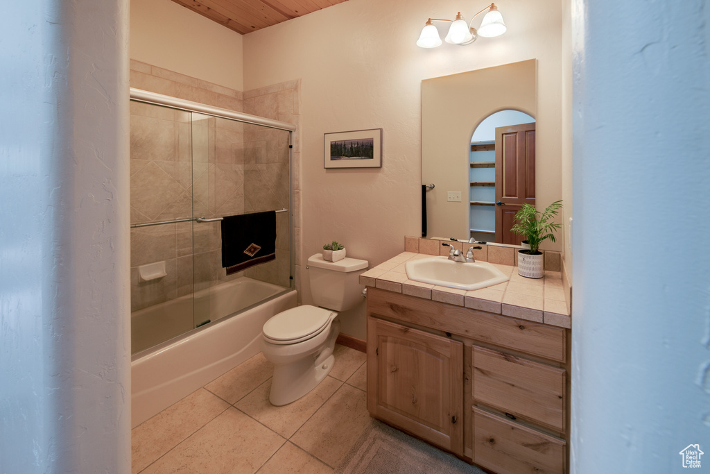 Full bathroom featuring wooden ceiling, toilet, large vanity, enclosed tub / shower combo, and tile flooring