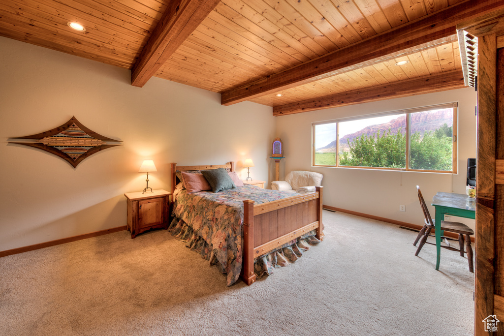 Bedroom with beamed ceiling, light colored carpet, and wood ceiling
