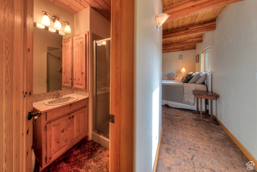 Bathroom featuring beam ceiling, wooden ceiling, vanity, and a shower with door