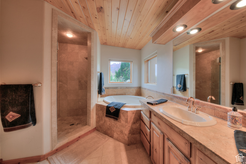Bathroom featuring tile floors, vanity with extensive cabinet space, plus walk in shower, and wood ceiling