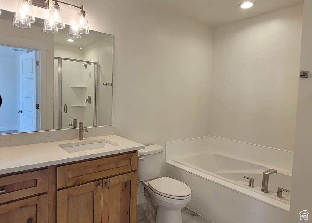 Bathroom with vanity, toilet, tile floors, and tiled tub