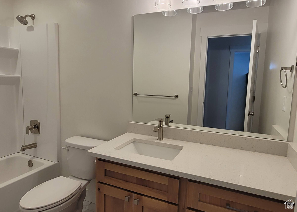 Full bathroom with tub / shower combination, tile floors, toilet, and vanity with extensive cabinet space