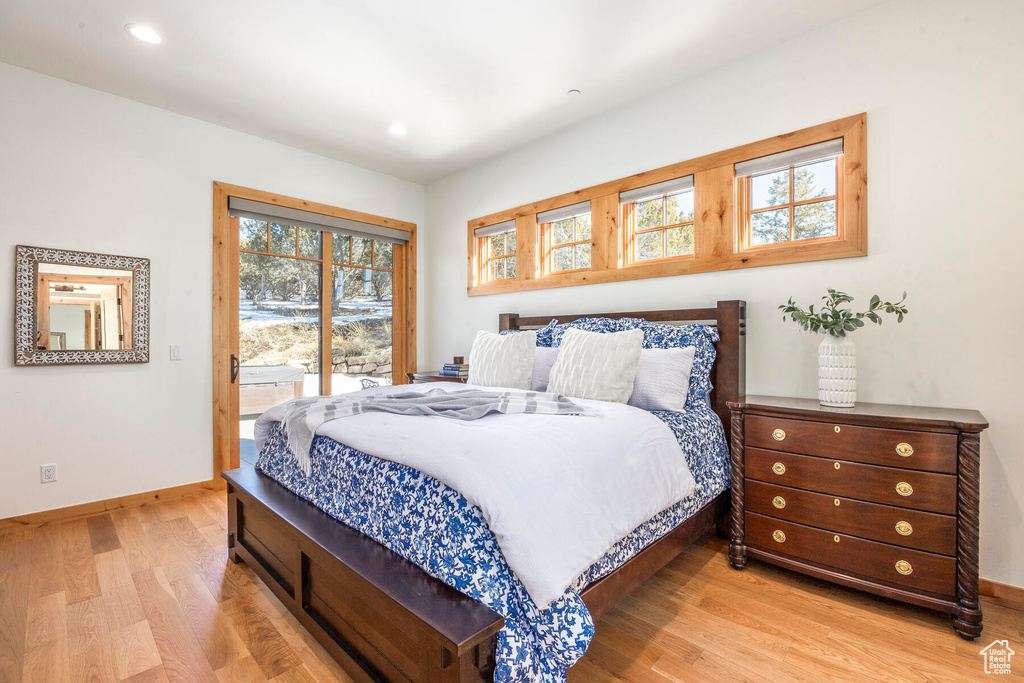 Bedroom featuring multiple windows, light hardwood / wood-style flooring, and access to outside