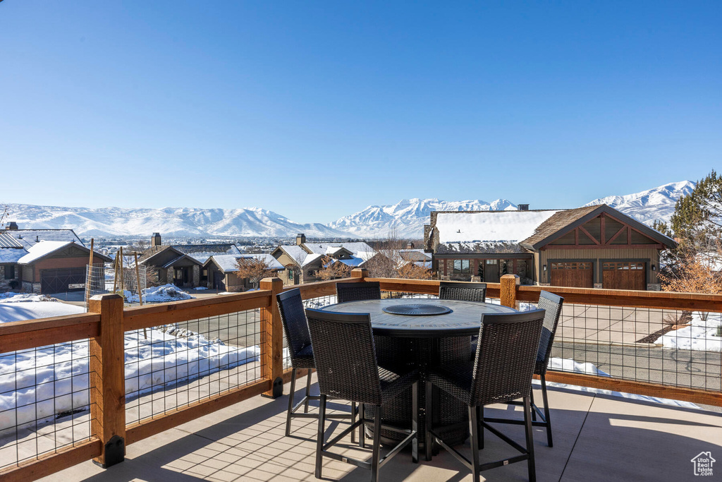 Snow covered deck featuring a patio area and a mountain view