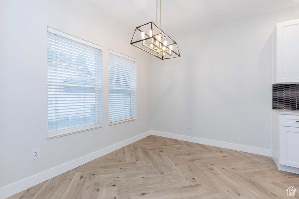 Unfurnished room featuring an inviting chandelier and light parquet flooring