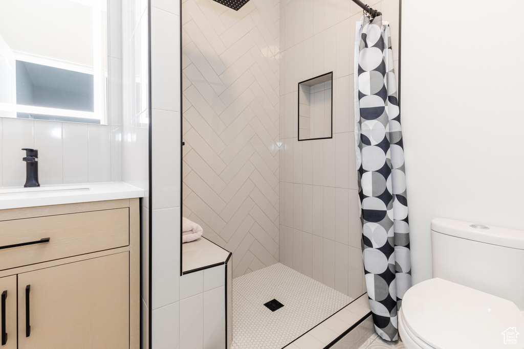 Bathroom with vanity, toilet, and curtained shower