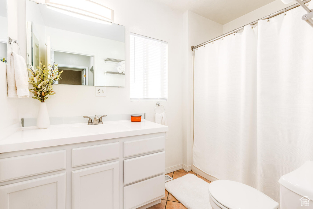 Bathroom featuring large vanity, tile flooring, and toilet