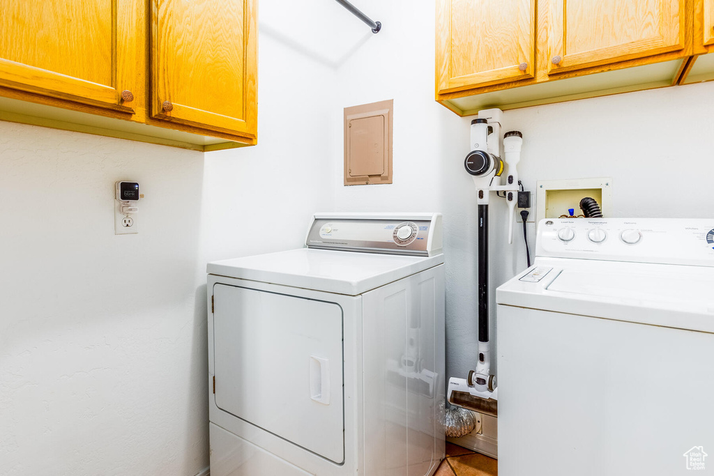 Washroom with cabinets, washer hookup, and washing machine and clothes dryer