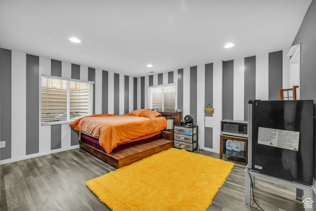Bedroom featuring black fridge and hardwood / wood-style flooring