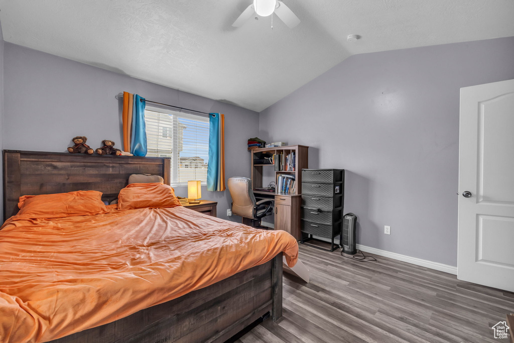 Bedroom featuring dark wood-type flooring, lofted ceiling, and ceiling fan