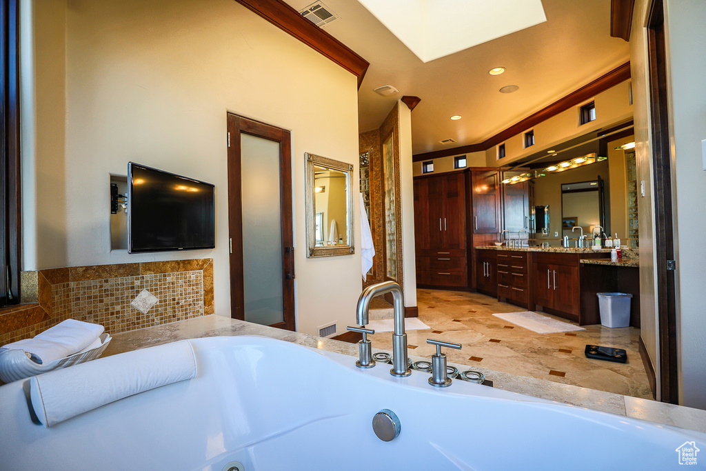 Bathroom with tile floors, vanity, and a bath to relax in