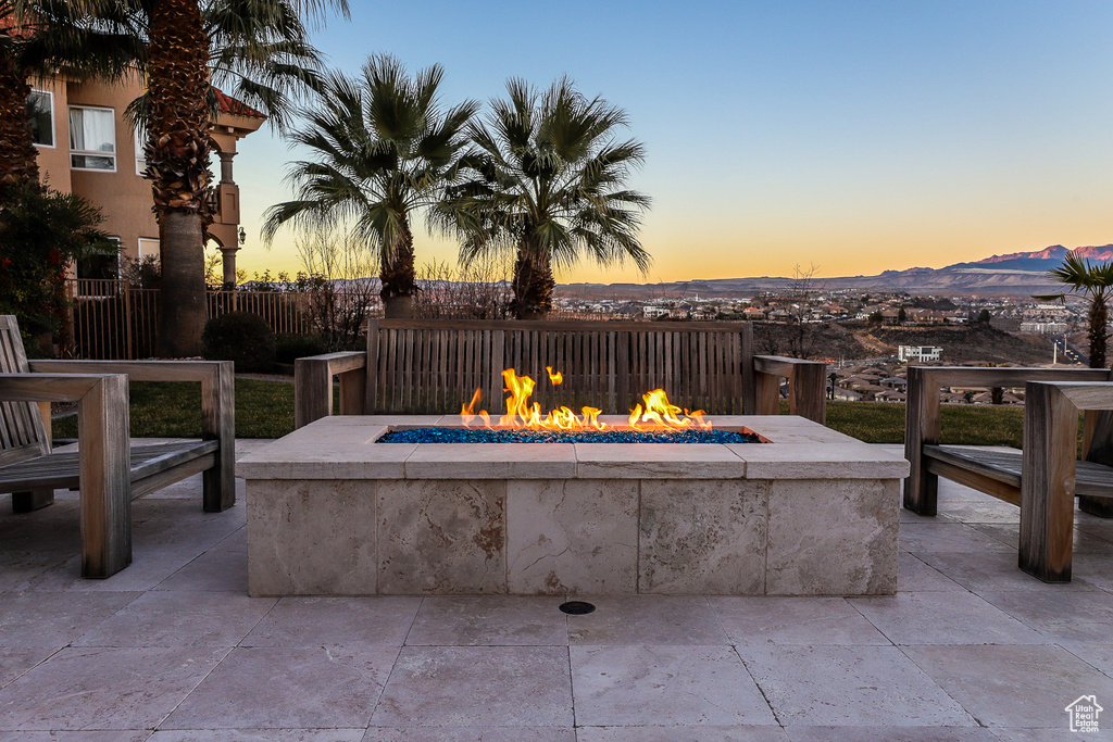 Patio terrace at dusk with a fire pit and a mountain view