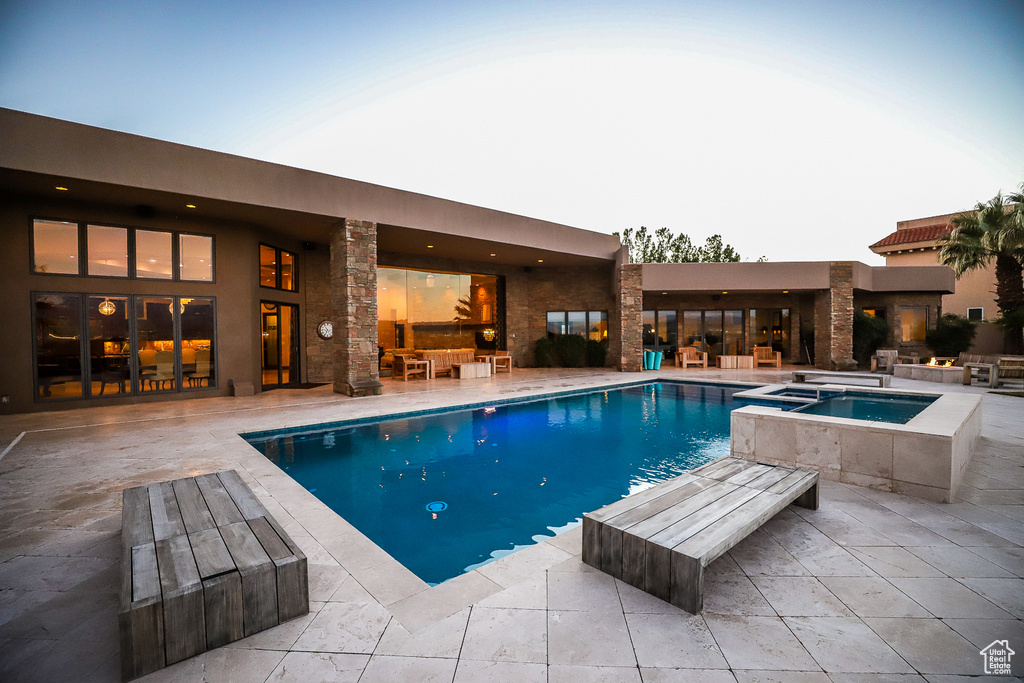 View of swimming pool with a patio area and an in ground hot tub