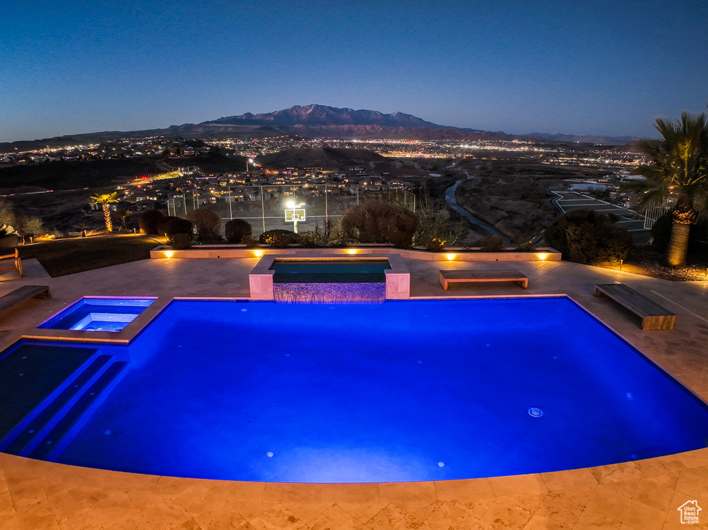 View of swimming pool with a mountain view and an in ground hot tub