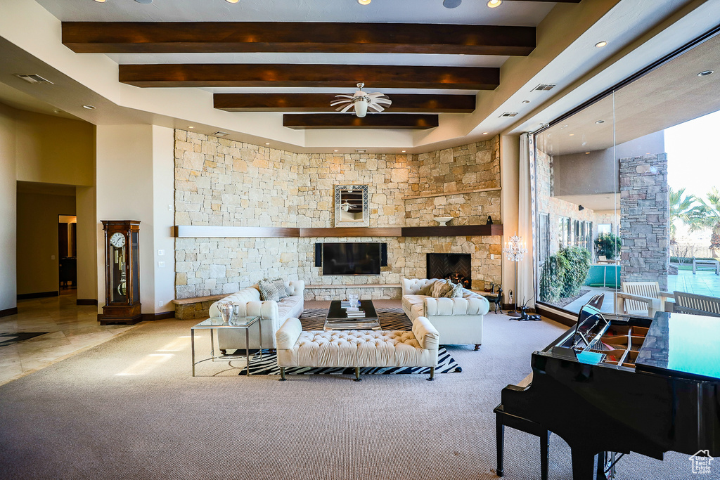 Living room featuring beam ceiling, a stone fireplace, light tile flooring, and ceiling fan