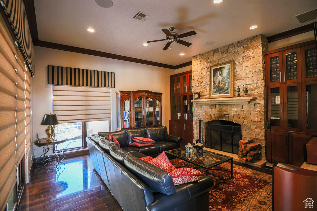 Living room with crown molding, a fireplace, and ceiling fan