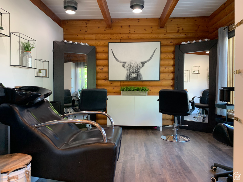 Living room featuring dark hardwood / wood-style flooring, wooden ceiling, beamed ceiling, and rustic walls